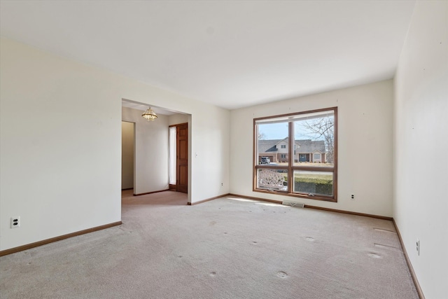 carpeted empty room featuring visible vents and baseboards