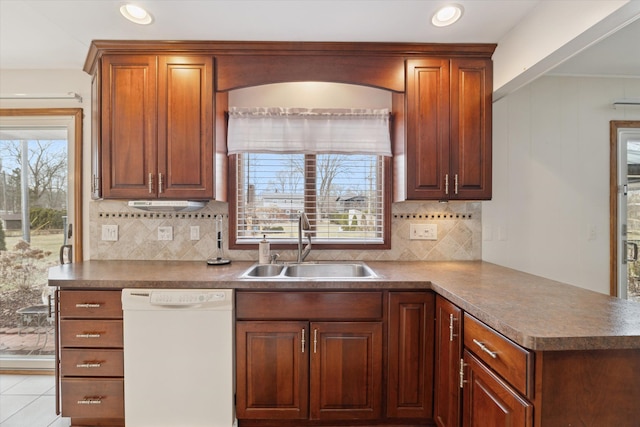 kitchen featuring decorative backsplash, dishwasher, a peninsula, a sink, and recessed lighting