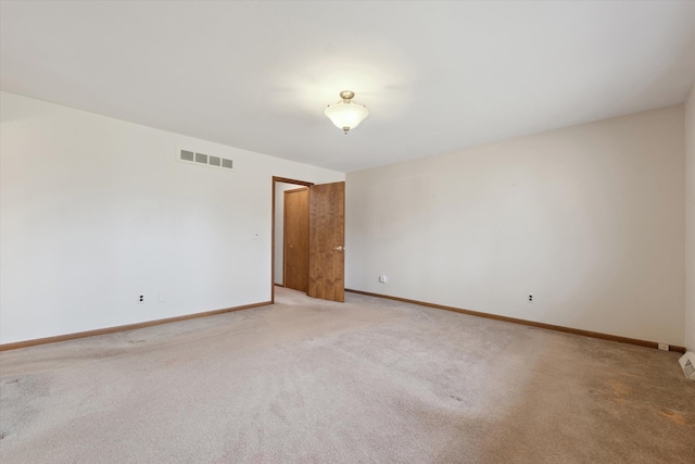 empty room with light carpet, baseboards, and visible vents