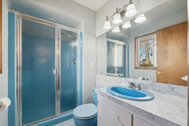 bathroom with toilet, a stall shower, and vanity