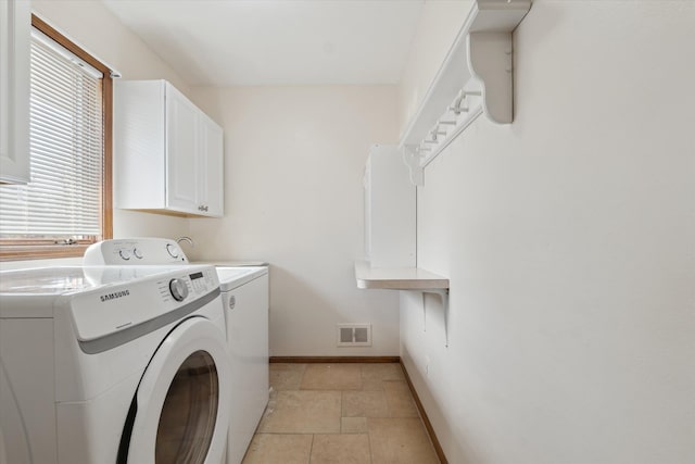 clothes washing area with cabinet space, stone tile floors, visible vents, baseboards, and separate washer and dryer