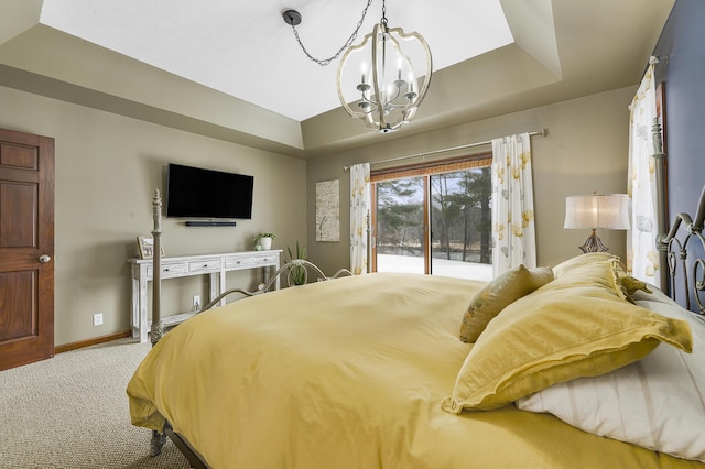 carpeted bedroom with access to outside, a raised ceiling, a notable chandelier, and baseboards