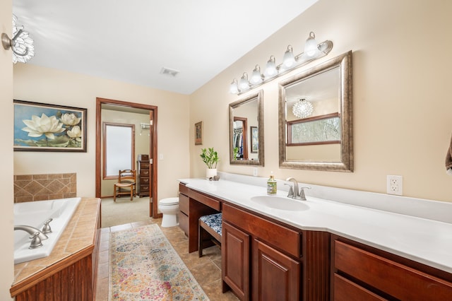 full bathroom featuring visible vents, toilet, vanity, a bath, and tile patterned floors