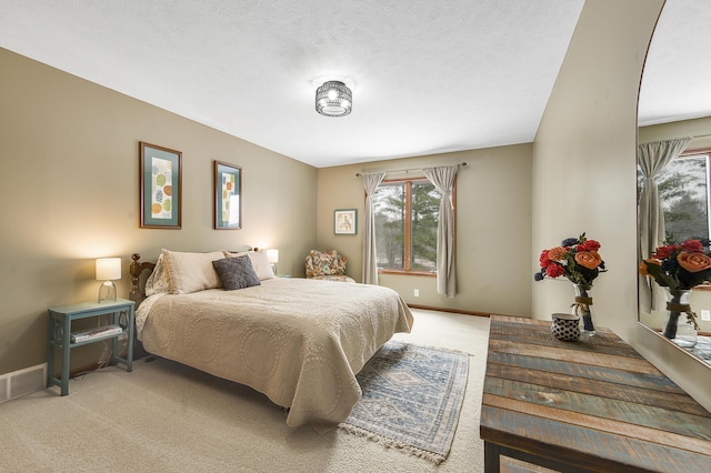 bedroom featuring visible vents, light carpet, a textured ceiling, and baseboards