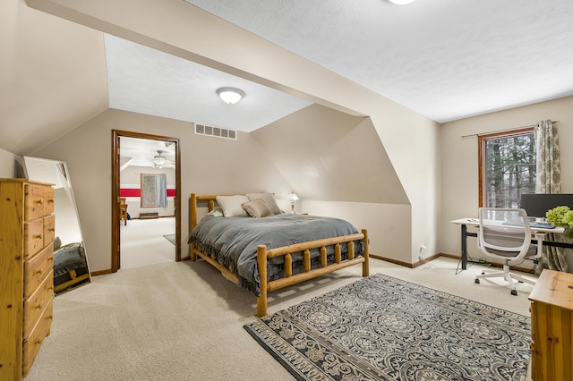 bedroom featuring a textured ceiling, lofted ceiling, light carpet, visible vents, and baseboards