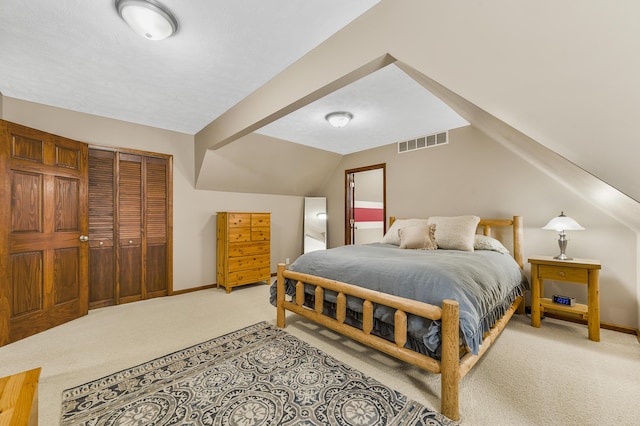 bedroom featuring baseboards, visible vents, light colored carpet, vaulted ceiling, and a closet