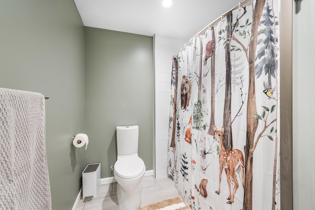 full bath featuring a shower with curtain, baseboards, and toilet