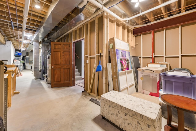 unfinished basement featuring stairway and gas water heater