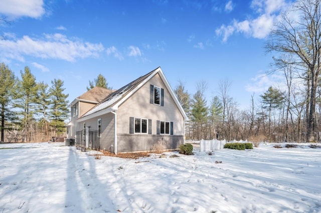 snow covered property with central air condition unit