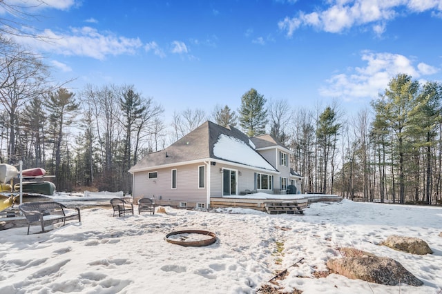 snow covered property with a fire pit and a wooden deck