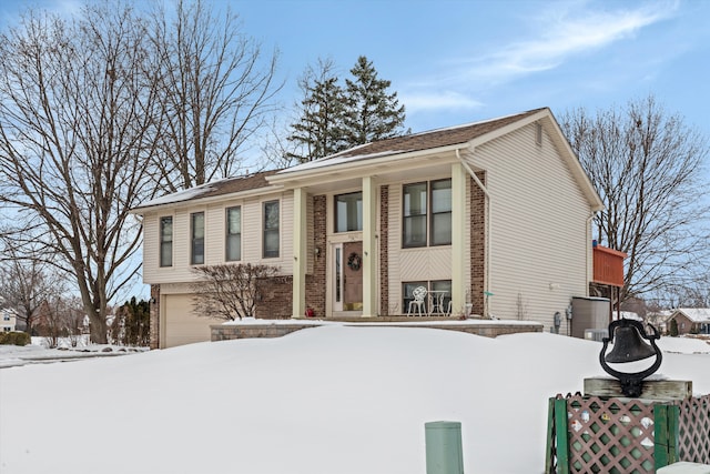 raised ranch with brick siding and an attached garage