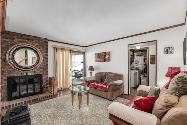 living area featuring ornamental molding, a brick fireplace, and wood finished floors