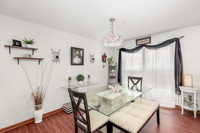 dining space featuring baseboards and wood finished floors