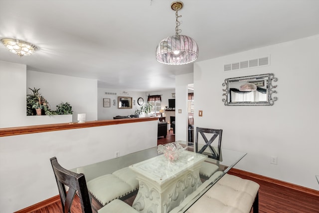 dining space with visible vents, baseboards, and wood finished floors