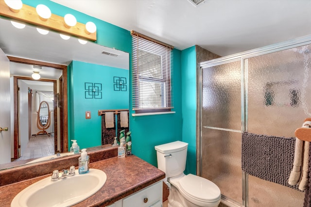 bathroom with a stall shower, visible vents, vanity, and toilet