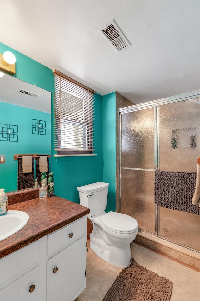 bathroom featuring tile patterned flooring, toilet, vanity, visible vents, and a shower stall