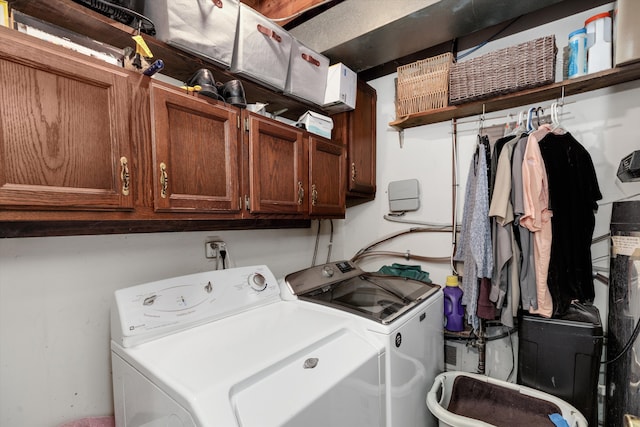 laundry room featuring separate washer and dryer and cabinet space