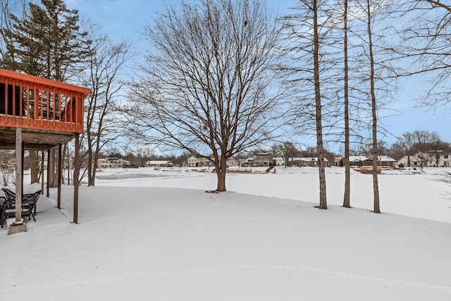 yard covered in snow featuring a deck