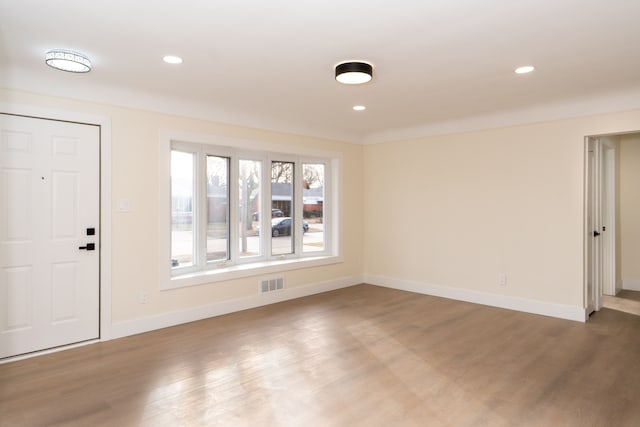 spare room with baseboards, visible vents, wood finished floors, and recessed lighting