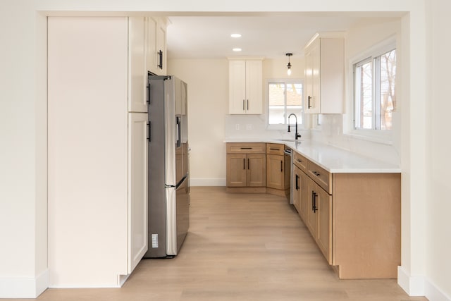 kitchen with light wood-style flooring, recessed lighting, a sink, appliances with stainless steel finishes, and backsplash