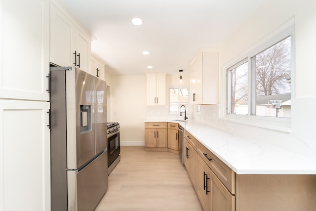 kitchen with light wood-style flooring, recessed lighting, a sink, white cabinetry, and appliances with stainless steel finishes