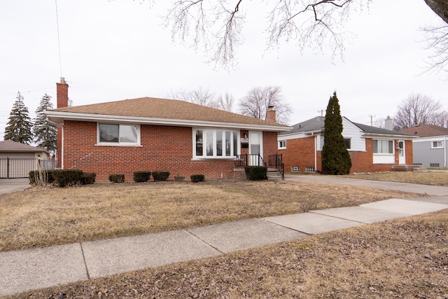 view of front facade featuring brick siding, a chimney, and roof with shingles