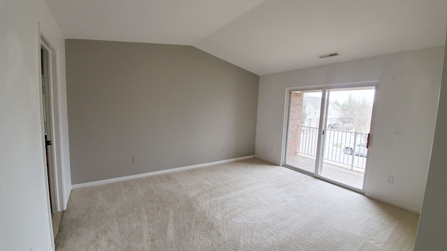 spare room with visible vents, light colored carpet, baseboards, and lofted ceiling