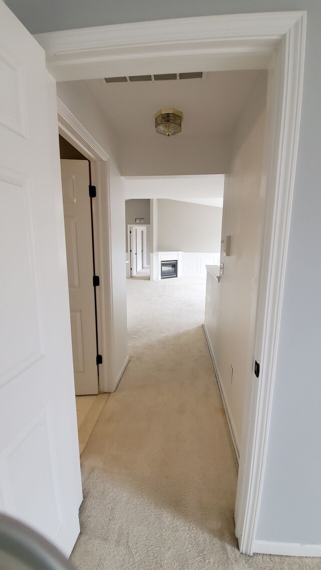 corridor featuring light carpet and baseboards