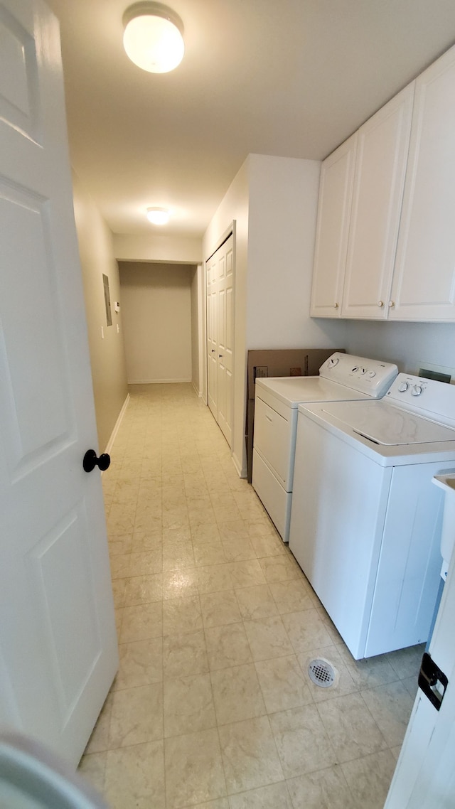 laundry area featuring baseboards, cabinet space, and independent washer and dryer