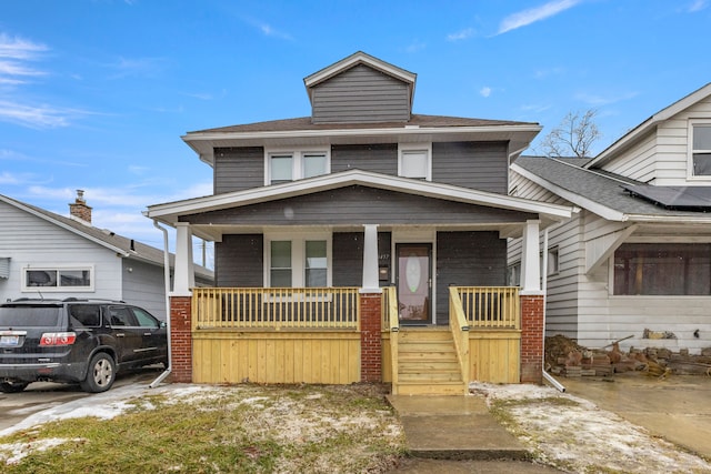 american foursquare style home featuring a porch