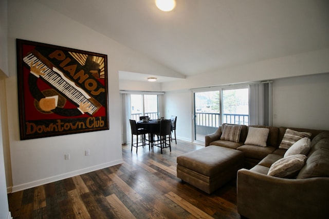 living area featuring lofted ceiling, baseboards, and wood finished floors