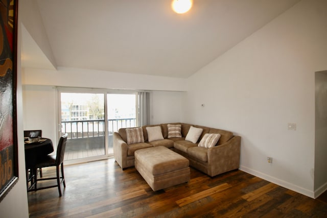 living room with dark wood-style floors, lofted ceiling, and baseboards