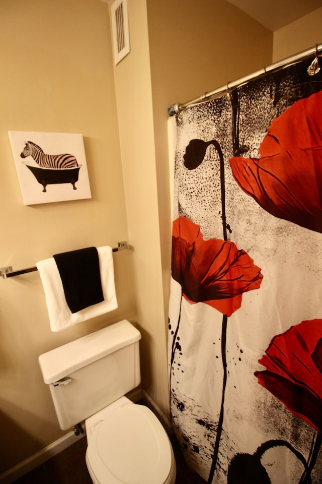 bathroom with visible vents, curtained shower, and toilet