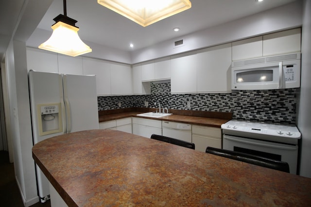 kitchen featuring white appliances, dark countertops, white cabinetry, and tasteful backsplash