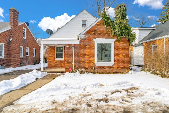 snow covered house with brick siding