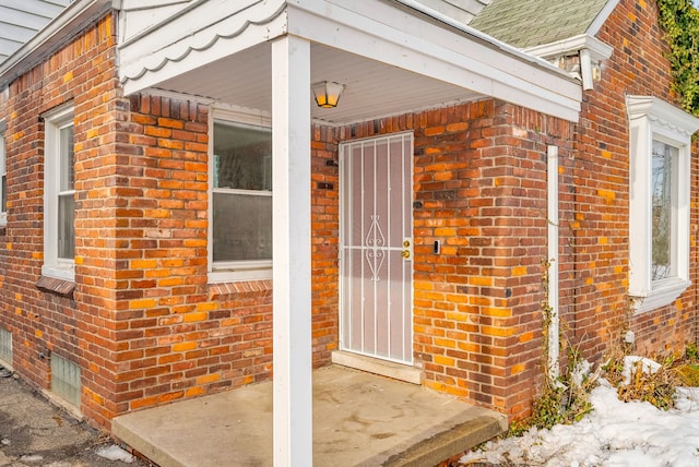 doorway to property featuring brick siding