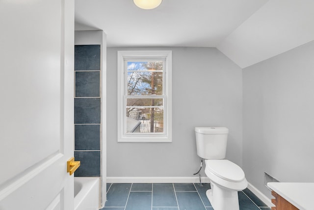 full bath with a bathing tub, toilet, baseboards, vaulted ceiling, and tile patterned floors