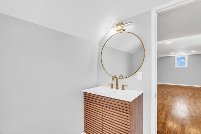 bathroom featuring visible vents, vaulted ceiling, hardwood / wood-style floors, and vanity