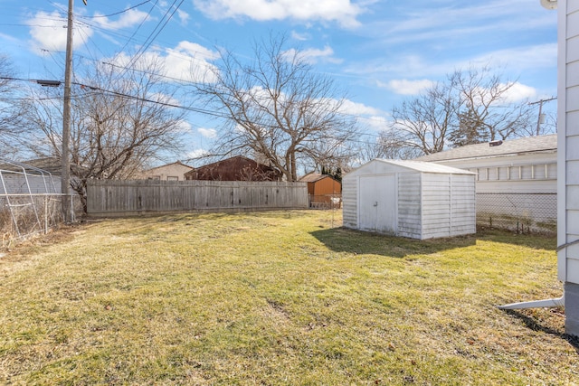 view of yard featuring a storage shed, a fenced backyard, and an outdoor structure