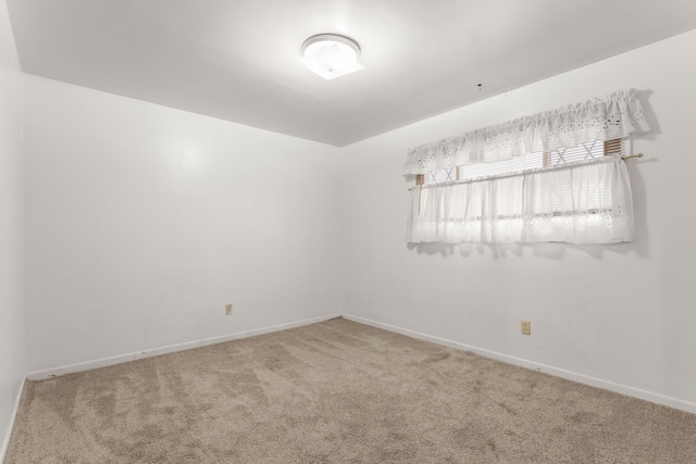 carpeted empty room with baseboards