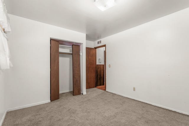 unfurnished bedroom with a closet, carpet flooring, visible vents, and baseboards