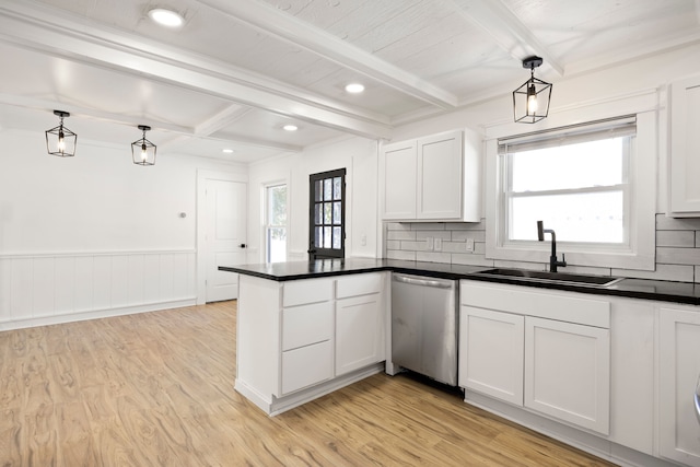 kitchen featuring a peninsula, a sink, dishwasher, beamed ceiling, and dark countertops