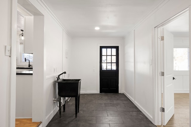 entrance foyer featuring a healthy amount of sunlight, baseboards, and crown molding