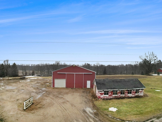 view of pole building with a lawn and dirt driveway