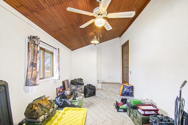 interior space with a ceiling fan, wood ceiling, and carpet flooring