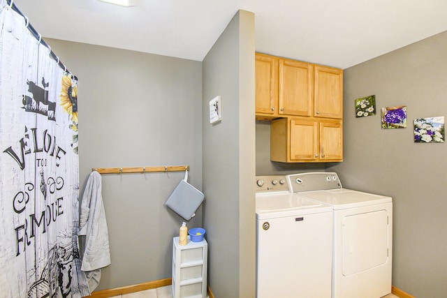 washroom with cabinet space, washer and clothes dryer, and baseboards