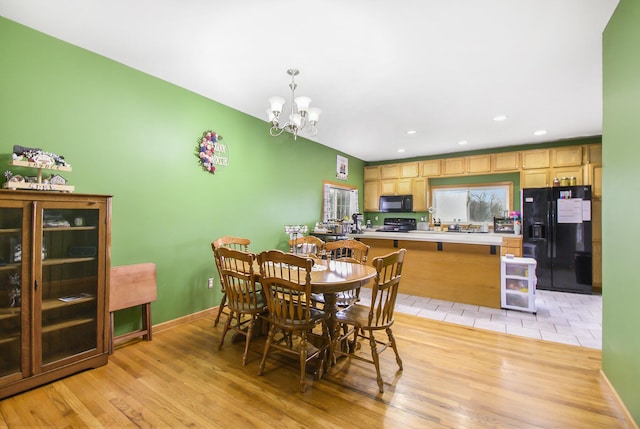 dining space with a chandelier, baseboards, light wood-style flooring, and recessed lighting