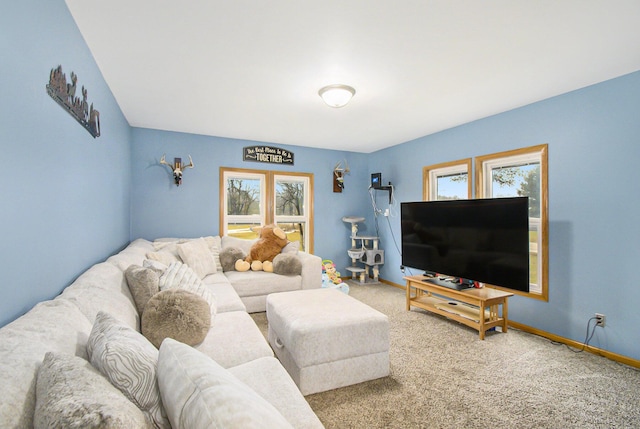 living room featuring carpet, plenty of natural light, and baseboards