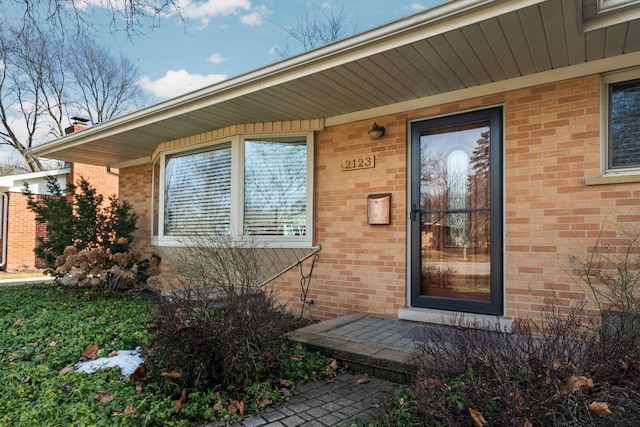 view of exterior entry with brick siding