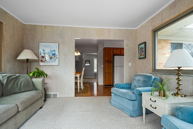 carpeted living room featuring ornamental molding and visible vents